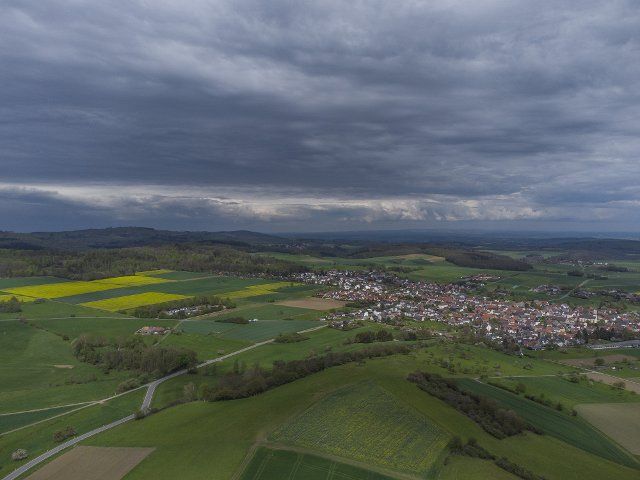 13 May 2021, Hessen, Eschbach: Dark clouds form in the sky above Eschbach im Taunus (aerial photo taken with a drone). The weather remains changeable. Photo: Boris Roessler\/dpa