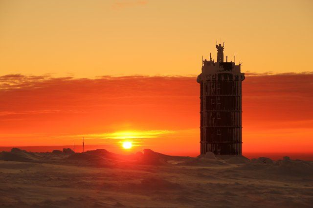 20 March 2021, Saxony-Anhalt, Schierke: Sunrise on the Brocken with a view of the weather station. On the highest mountain in the Harz, the beginning of the calendrical spring was welcomed with frosty minus 12 degrees Celsius. Photo: Matthias Bein\/dpa-Zentralbild\/dpa