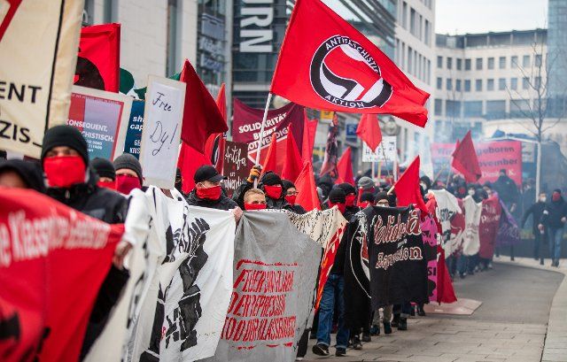 20 March 2021, Baden-Wuerttemberg, Stuttgart: Left-wing demonstrators parade through the city centre with flags and banners. Several demonstrations on various topics were registered in Stuttgart on Saturday. Photo: Christoph Schmidt\/dpa