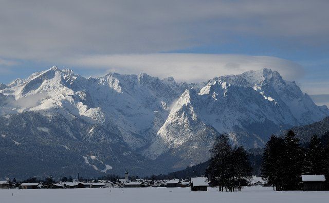 23 March 2021, Bavaria, Garmisch-Partenkirchen: Clouds are moving over the snow-covered peaks in the Wetterstein mountains, on the left you can see the Alpspitze and on the right the Zugspitze. Photo: Angelika Warmuth\/dpa