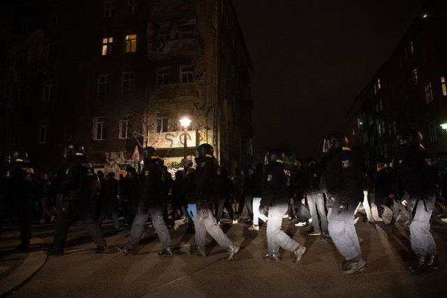23 March 2021, Berlin: Police officers accompany demonstrators in Rigaer Straße protesting against the eviction of the scene pub "Meuterei". On Thursday, the pub in Reichenberger Straße is to be evicted. The police expect a larger deployment to secure the bailiff at work. Photo: Paul Zinken\/dpa-Zentralbild\/dpa