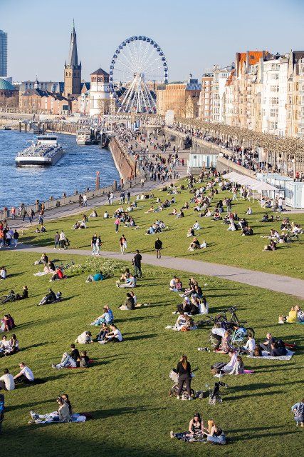29 March 2021, North Rhine-Westphalia, Duesseldorf: Numerous people stroll along the Rhine promenade in summery 21 degrees and sunshine. Photo: Marcel Kusch\/dpa