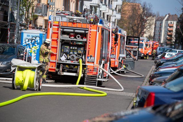 11 April 2021, Berlin: Fire engines stand in a street in Friedrichshain where there was a fire in an apartment building. (to dpa: "Fire in attic construction site in apartment building") Photo: Christophe Gateau\/dpa