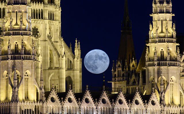 dpatop - 24 June 2021, Hungary, Budapest: The full moon rises over the parliament building on the Danube in the evening. Photo: Robert Michael\/dpa-Zentralbild\/dpa