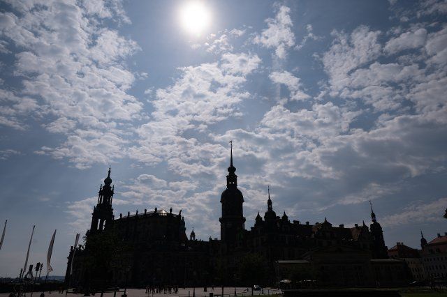 28 June 2021, Saxony, Dresden: The backdrop of the Catholic Court Church (l) and the Residence Palace stand out as a silhouette on Theaterplatz. Photo: Sebastian Kahnert\/dpa-Zentralbild\/ZB