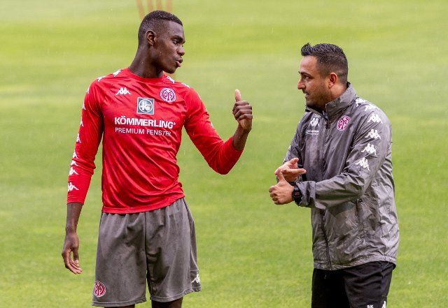 29 June 2021, Rhineland-Palatinate, Mainz: Football: Bundesliga, training kick-off FSV Mainz 05. Moussa Niakhate talking to Mainz co-trainer Babak Keyhanfar (r.). The players only trained for a few minutes, then the warm-up was interrupted due to a thunderstorm. Photo: Torsten Silz\/dpa
