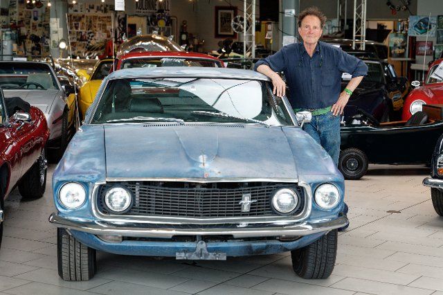 09 July 2021, North Rhine-Westphalia, Mettmann: Classic car dealer Michael Fröhlich stands next to a Ford Mustang said to have belonged to actor Steve McQueen. Photo: Henning Kaiser\/dpa