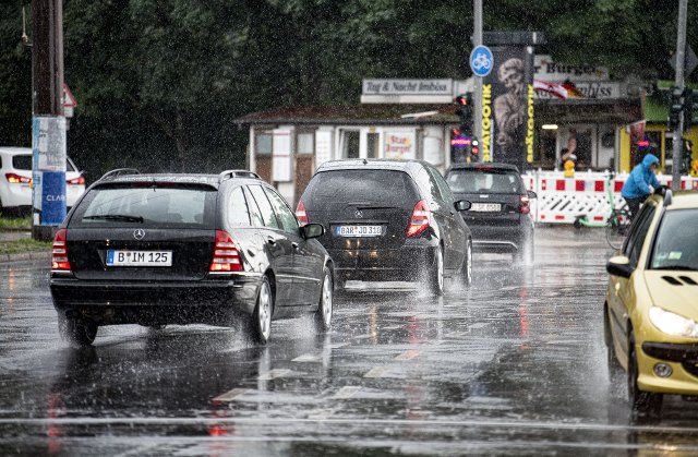 15 July 2021, Berlin: Cars drive through an intersection during heavy rainfall. Photo: Fabian Sommer\/dpa
