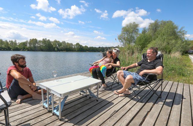 29 May 2021, Baden-Wuerttemberg, Ertingen: A family sits in the sunshine at the Schwarzachtalsee and has a picnic. Photo: Thomas Warnack\/dpa