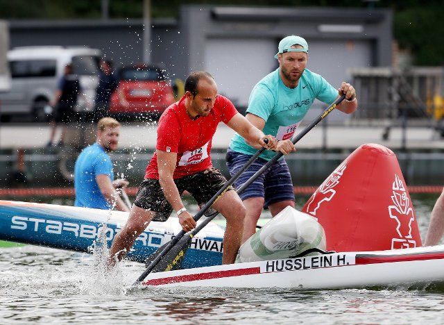 03 June 2021, North Rhine-Westphalia, Duisburg: Canoe: SUP, German Championship. Standup paddlers Hermann Husslein (l) and Denny Kambs sail around a buoy. Photo: Roland Weihrauch\/dpa
