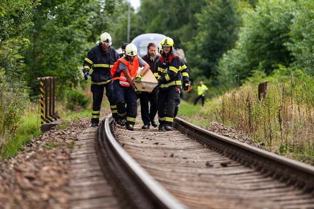 04 August 2021, Czech Republic, MilavÂ·e: Firefighters and undertakers carry a coffin on the tracks. An express train coming from Munich collided head-on with an oncoming regional train here. In addition to the two train drivers - both Czech nationals - a woman from the regional railcar was killed, according to police. Photo: Nicolas Armer\/dpa