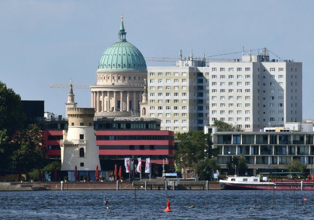 16 August 2021, Brandenburg, Potsdam: When looking from the Glienicke Bridge with a telephoto lens, the Nikolai Church stands directly next to the prefabricated buildings of the city. Photo: Bernd Settnik\/dpa\/ZB