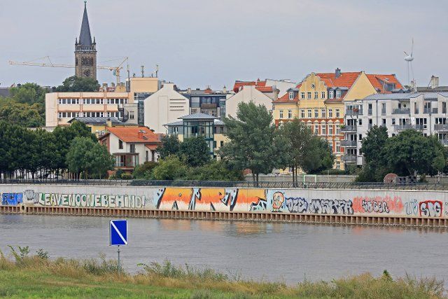 19 August 2021, Saxony-Anhalt, Magdeburg: The graffiti smearings on the bank wall of the Buckau district in the state capital extend over several hundred meters.illegal inscriptions by the spayers occur here again and again. Illegal graffiti on public buildings or bridges cost the municipalities in Saxony-Anhalt five-figure sums every year. (to dpa "Graffiti removal costs municipalities tens of thousands of euros") Photo: Peter Gercke\/dpa-Zentralbild\/dpa