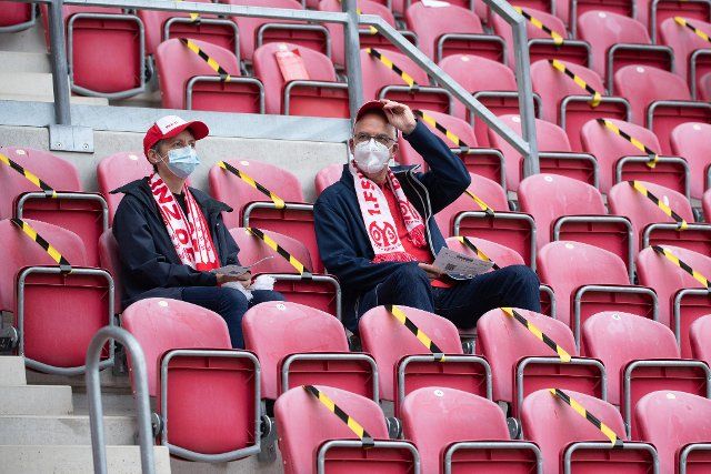 28 August 2021, Rhineland-Palatinate, Mainz: Football: Bundesliga, FSV Mainz 05 - SpVgg Greuther Fürth, Matchday 3, at Mewa Arena. Fans sit in the stadium with masks before the match. Photo: Sebastian Gollnow\/dpa - IMPORTANT NOTE: In accordance with the regulations of the DFL Deutsche Fußball Liga and\/or the DFB Deutscher Fußball-Bund, it is prohibited to use or have used photographs taken in the stadium and\/or of the match in the form of sequence pictures and\/or video-like photo series