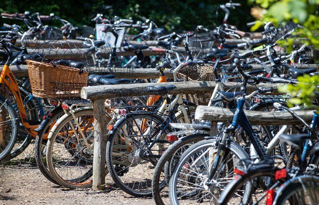 15 July 2021, Mecklenburg-Western Pomerania, Prerow: Bicycles are parked in a two-wheeler parking lot at the beach entrance. The two police headquarters in Mecklenburg-Vorpommern received fewer reports of stolen bicycles in the first half of 2021. Photo: Jens Büttner\/dpa-Zentralbild\/dpa