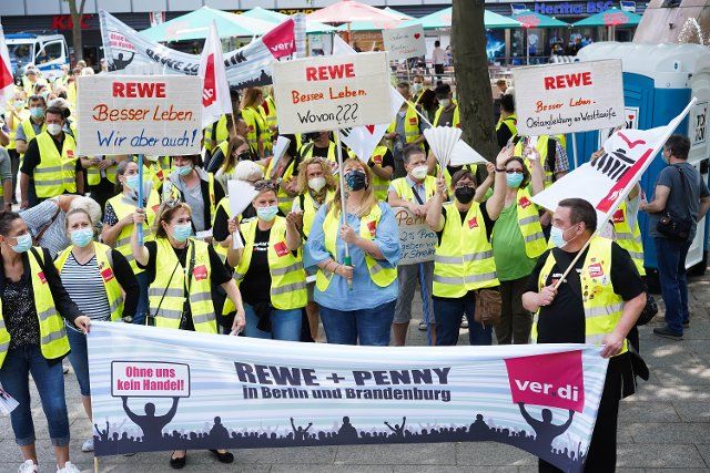 23 July 2021, Berlin: As part of a strike, employees from Berlin and Brandenburg retail companies demonstrate on Breitscheidplatz for a higher salary. The trade union Verdi had called for the warning strike. Companies such as Rewe, EDEKA, Kaufland, Penny and Ikea are affected. Among other things, the union is demanding a minimum wage of 12.50 euros per hour. Photo: JÃ¶rg Carstensen\/dpa