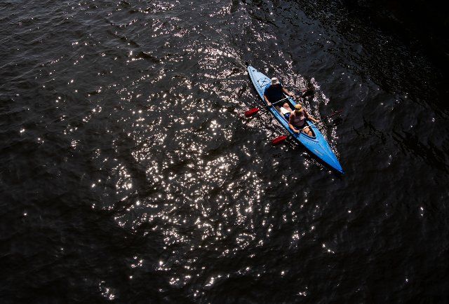 25 July 2021, Berlin: A woman and a man are travelling in a canoe on the Spree. Photo: Paul Zinken\/dpa