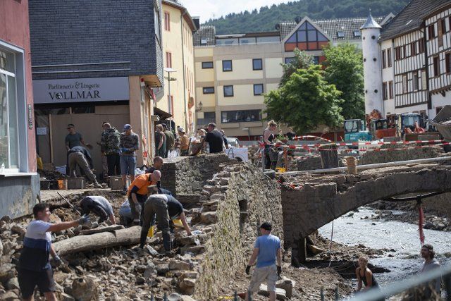 24 July 2021, North Rhine-Westphalia, Bad Münstereifel: Numerous helpers clear away debris and rubble. After last week\