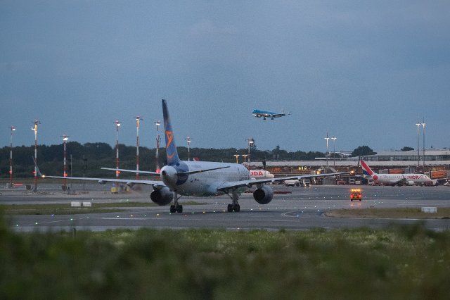 26 July 2021, Hamburg: One aircraft is approaching Helmut Schmidt Airport in the evening while another that has already landed is being guided to the terminal. Photo: Jonas Walzberg\/dpa