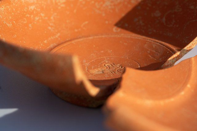 01 October 2021, Bavaria, Deiningen: There is an engraved cross on a broken ceramic bowl. During excavations in the Nördlinger Ries, archaeologists found this bowl, which originated in Africa, among other grave goods in a grave from the 6th century. Photo: Stefan Puchner\/dpa