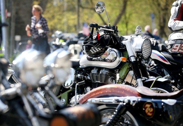 PRODUCTION - 28 April 2021, North Rhine-Westphalia, Essen: Motorcyclists chatting behind their parked machines at a motorcycle meeting point on Lake Baldeney. The sunny weather and slightly warmer temperatures are driving motorcyclists back onto the roads. Photo: Roland Weihrauch\/dpa