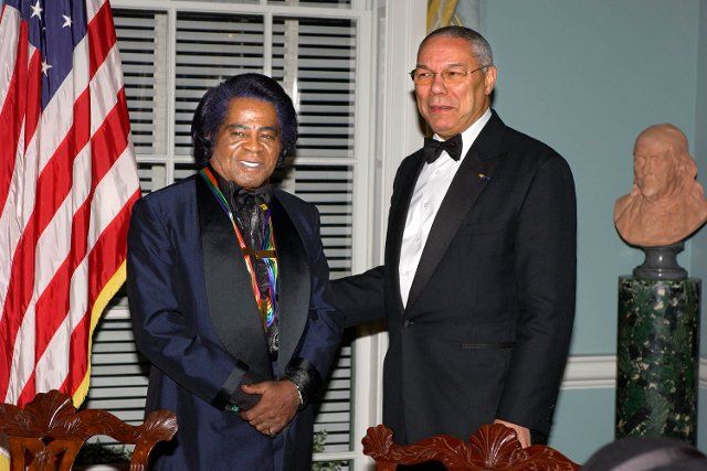 Musician James Brown, left, one of the 2003 Kennedy Center honorees, talking with United States Secretary of State Colin Powell after a dinner in his honor at the United States Department of State in Washington, DC on December 6, 2003
