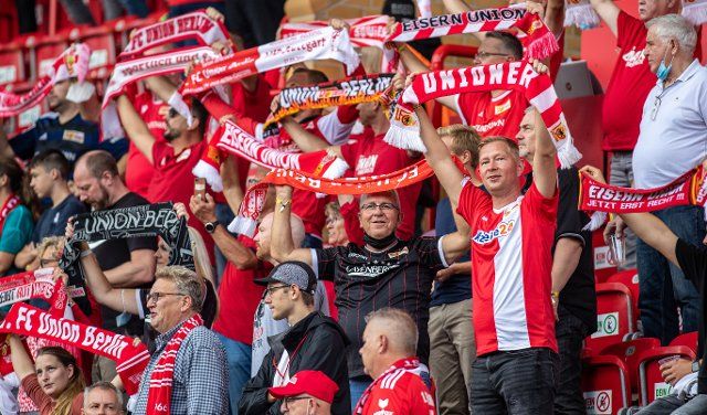 11 September 2021, Berlin: Football: Bundesliga, 1. FC Union Berlin - FC Augsburg, Matchday 4, An der Alten Försterei. Union Berlin fans cheer on their team with scarves. Photo: Andreas Gora\/dpa - IMPORTANT NOTE: In accordance with the regulations of the DFL Deutsche Fußball Liga and\/or the DFB Deutscher Fußball-Bund, it is prohibited to use or have used photographs taken in the stadium and\/or of the match in the form of sequence pictures and\/or video-like photo series