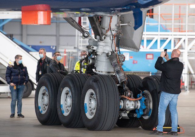 19 November 2021, Hessen, Frankfurt\/Main: The Boeing 777-9 is presented during a short visit to a Lufthansa hangar at the airport. Guests take photos of the landing gear. Photo: Boris Roessler\/dpa