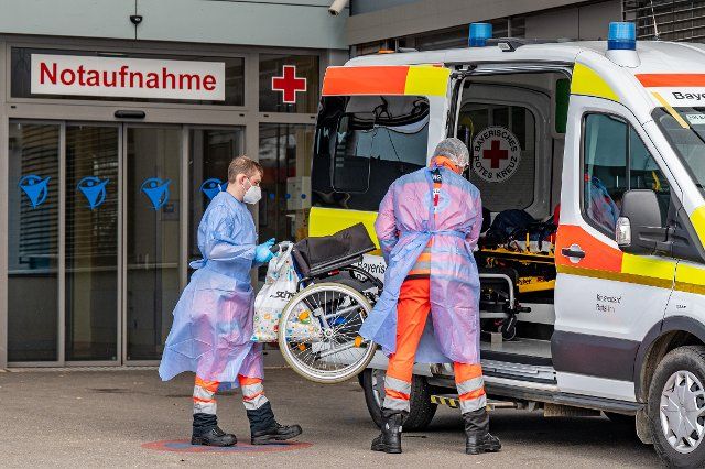 19 November 2021, Bavaria, Eggenfelden: Employees of the Red Cross lift a wheelchair into an ambulance parked in front of the emergency room of the Rottal-Inn clinics. The district of Rottal-Inn continues to have the highest incidence in Bavaria with 1423.6. Photo: Armin Weigel\/dpa