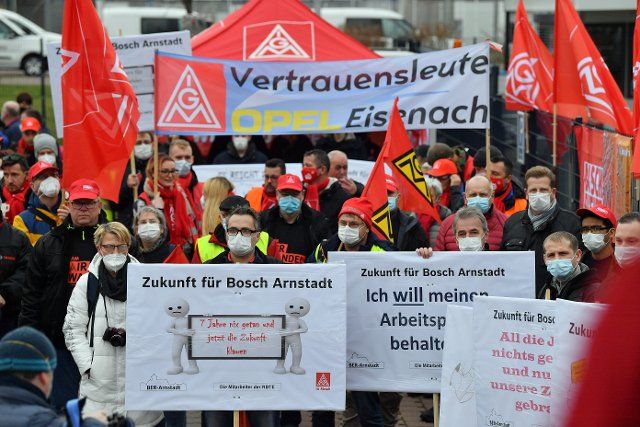 19 November 2021, Thuringia, Arnstadt: Employees stand together at a rally organized by IG Metall to save jobs at Bosch in Arnstadt. In July, Bosch announced that it would close the Arnstadt plant at the end of the year. Other locations are also affected by announced site closures. The Arnstadt Bosch plant produces alternator regulators for alternators. According to the company, 100 of the 160 associates will be affected by the closure. Photo: Martin Schutt\/dpa-Zentralbild\/dpa