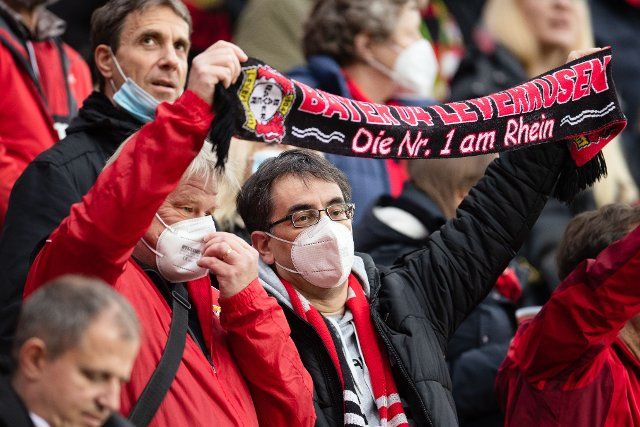 20 November 2021, North Rhine-Westphalia, Leverkusen: Football: Bundesliga, Bayer Leverkusen - VfL Bochum, Matchday 12, BayArena. Leverkusen fans wear FFP2 masks in the stands. Photo: Marius Becker\/dpa - IMPORTANT NOTE: In accordance with the regulations of the DFL Deutsche Fußball Liga and\/or the DFB Deutscher Fußball-Bund, it is prohibited to use or have used photographs taken in the stadium and\/or of the match in the form of sequence pictures and\/or video-like photo series