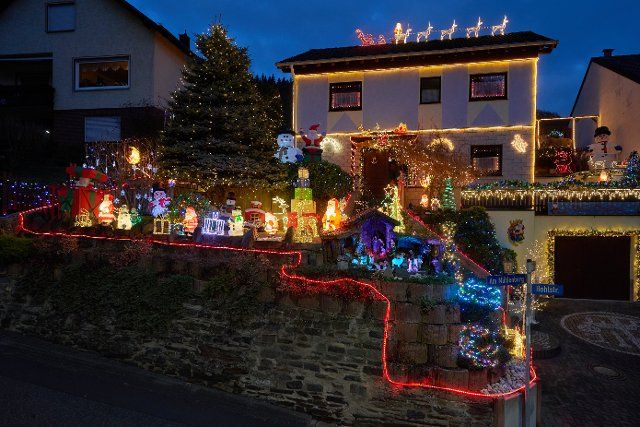 24 November 2021, Rhineland-Palatinate, Klotten: The house of pensioner Josef Johann in the Mosel village of Klotten shines in the glow of colorful Christmas decorations. After several weeks of preparation, he wants to switch everything on from the first Advent (28.11.). (To dpa: House of lights and giant candle - joy over Advent lighting). Photo: Thomas Frey\/dpa