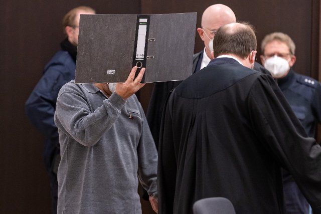 29 November 2021, Bavaria, Nuremberg: A man (l) accused of murder arrives at the start of the trial in the courtroom at the Criminal Justice Centre of the Nuremberg-FÃ¼rth Regional Court. The accused is alleged to have shot his separated wife in the street and an alleged rival in a taxi. Photo: Daniel Karmann\/dpa