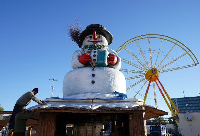 28 October 2021, Hamburg: Employees set up a booth with a snowman on the roof at Heiligengeistfeld. On November 5, the Hamburg Winterdom starts under 2G conditions on the Heiligengeistfeld. Photo: Marcus Brandt\/dpa