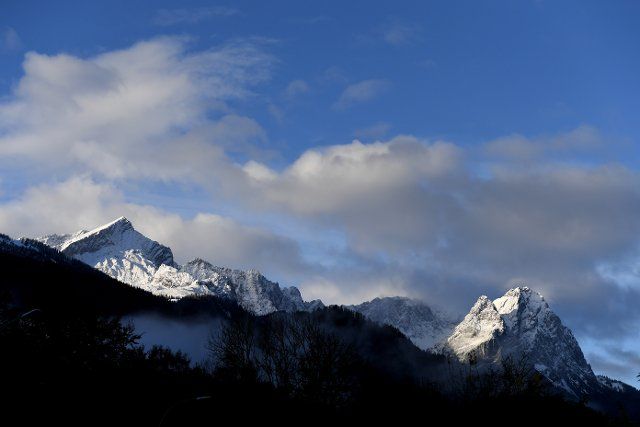 02 November 2021, Bavaria, Garmisch-Partenkirchen: Freshly covered with snow after the night, the summits of the Wetterstein Mountains with the Alpspitze (l) and the Zugspitze (r) are visible in the morning. Photo: Angelika Warmuth\/dpa