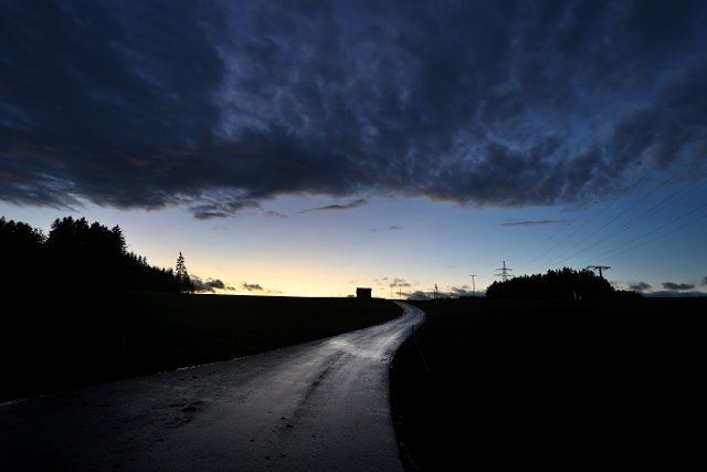02 November 2021, Bavaria, Aitrang: Clouds pass over a country road after sunset. Photo: Karl-Josef Hildenbrand\/dpa