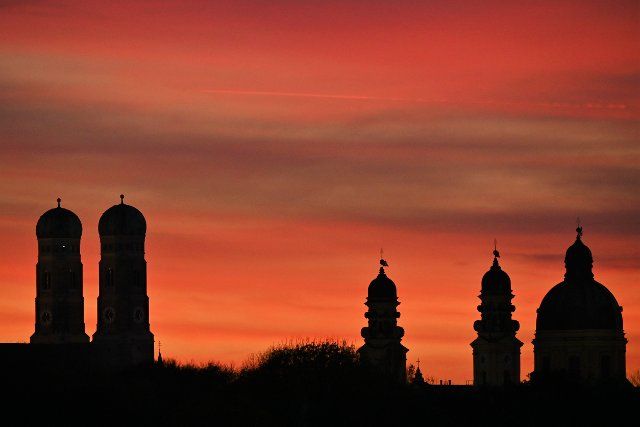 09 November 2021, Bavaria, Munich: The towers of the Frauenkirche and on the right the towers of the Theatinerkirche can be seen in the Munich sunset. Photo: Katrin Requadt\/dpa