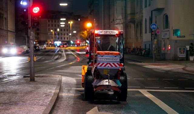 21 January 2022, Bavaria, Munich: A small snowplow stands at an intersection downtown. Photo: Sven Hoppe\/dpa