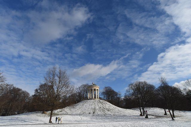 21 January 2022, Bavaria, Munich: Sunshine and blue sky walkers in the English Garden near the Monopteros. Snow and warmer temperatures invited to go out. Photo: Felix Hörhager\/dpa