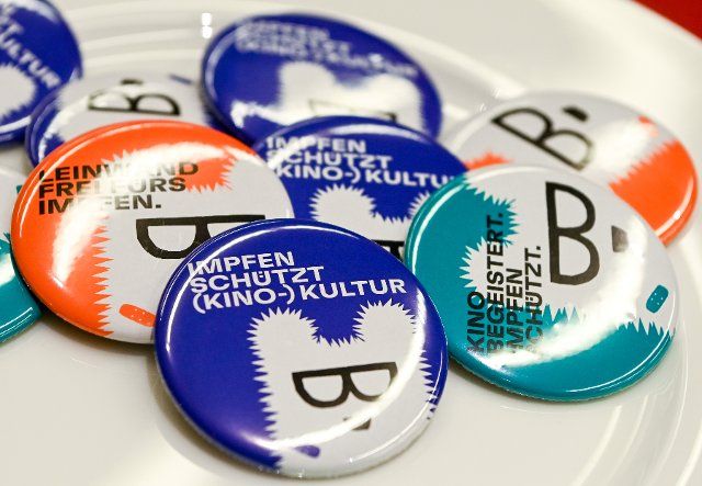 10 February 2022, Berlin: Buttons of the Berlinale promoting vaccination are in the press center of the film festival. The 72nd International Film Festival will take place from Feb. 10 to 20, 2022, despite rising corona infections. The award ceremony is already scheduled for Feb. 16, 2022. Photo: Jens Kalaene\/dpa-Zentralbild\/dpa