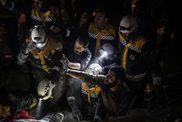 09 February 2022, Syria, Idlib City: Members of the Syria Civil Defence, known as White Helmets, attempt to rescue a family from under the rubble of a two-storey house which collapsed due to a heavy rain storm, killing a woman and her three children. Photo: Anas Alkharboutli\/dpa