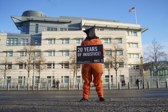 08 January 2022, Berlin: An Amnesty International activist in an orange jumpsuit with a bag over his head, protests for the closure of Guantanamo. Twenty years ago, the prison was opened. The protest takes place in several German cities. Photo: Joerg Carstensen\/dpa