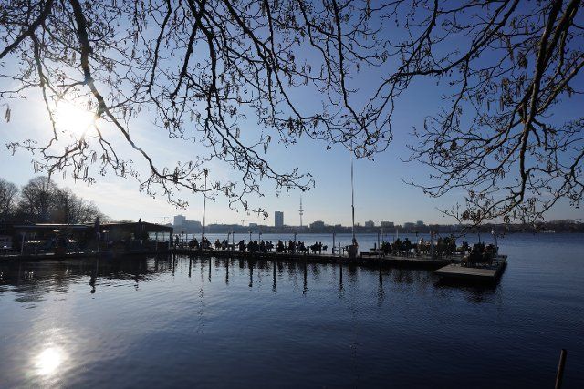 10 March 2022, Hamburg: Guests enjoy the afternoon sun on the jetty of the "Seehaus" on the Außenalster. Photo: Marcus Brandt\/dpa