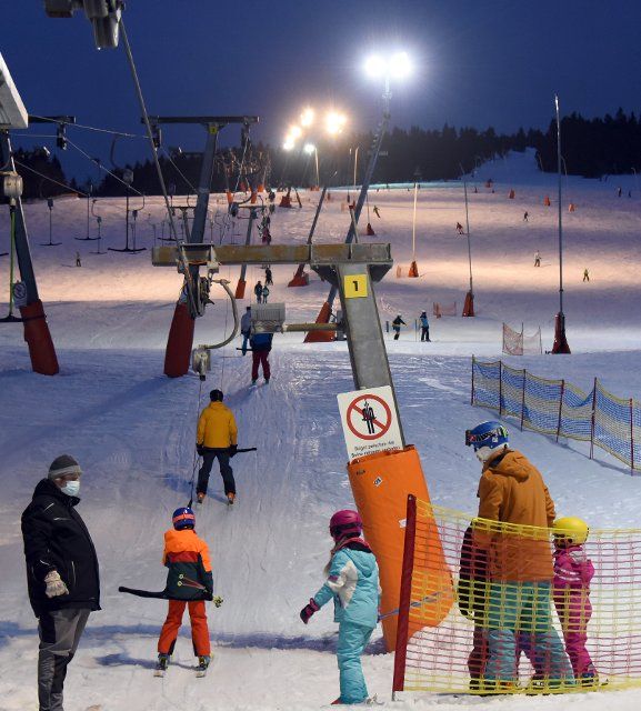 24 February 2022, Saxony, Oberwiesenthal: Many skiers use the illuminated ski slope from Fichtelberg for night skiing in the evening hours. Photo: Waltraud Grubitzsch\/dpa-Zentralbild\/ZB