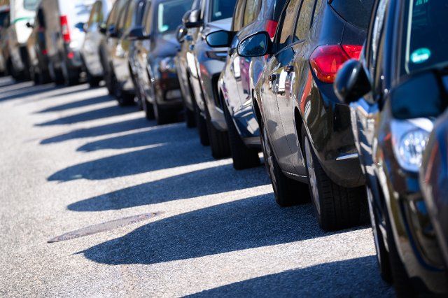27 March 2022, Hamburg: Numerous vehicles parked in the sunshine on a residential street. Photo: Jonas Walzberg\/dpa