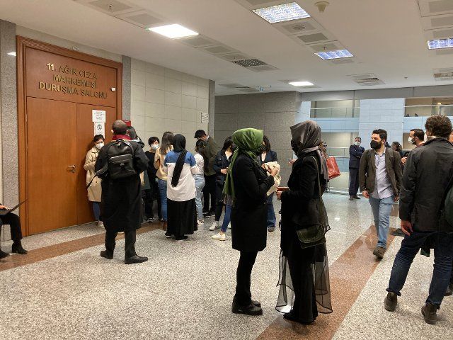 07 April 2022, ·stanbul, Istanbul: Hatice Cengiz (front right, gray headscarf) stands next to journalists and trial observers outside the courtroom before the start of the trial in the murder of Jamal Khashoggi at Istanbul\