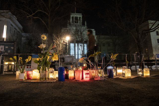 02 March 2022, Berlin: Candles and flowers in Ukrainian colors of yellow and blue are placed in front of the Russian Embassy to show solidarity and sympathy for Ukraine. Photo: Paul Zinken\/dpa