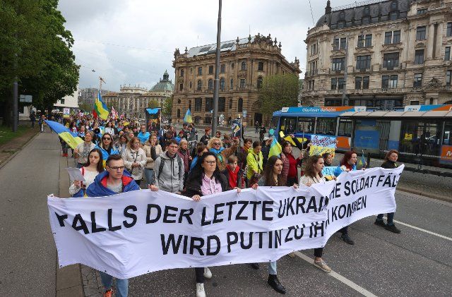 08 May 2022, Bavaria, Munich: Participants of a rally against the war in Ukraine march through the city center with a banner reading "If the last Ukrainian soldier falls. Putin will come to you". Photo: Karl-Josef Hildenbrand\/dpa