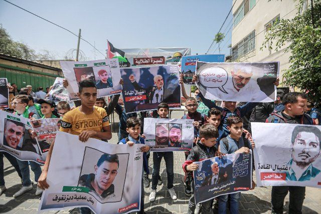 09 May 2022, Palestinian Territories, Gaza City: Palestinian students hold posters and placards during a protest in support of Yahya Sinwar, Hamas\