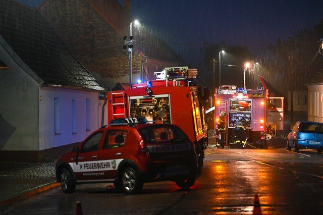 20 May 2022, Saxony-Anhalt, Osternienburg: Fire engines standing in the rain during an operation. In Osternienburg (Anhalt-Bitterfeld district), the fire departments from Trebbichau and Osternienburg had to pump water out of a building. Otherwise, the situation in the district was calm during the storm low Emmelinde. Photo: Heiko Rebsch\/dpa